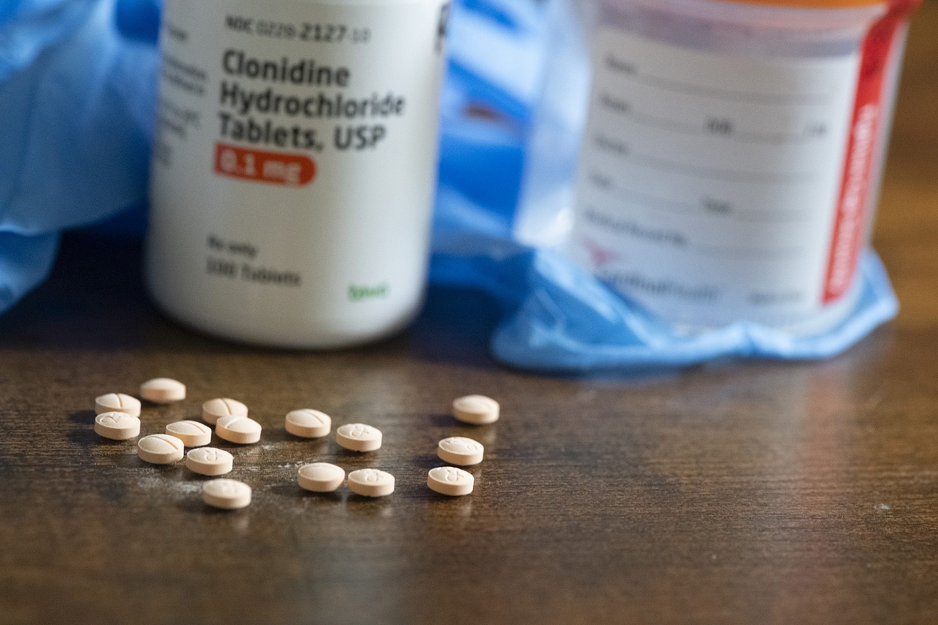 Prescription medication bottle and tablets used for blood pressure and kidney disease management.