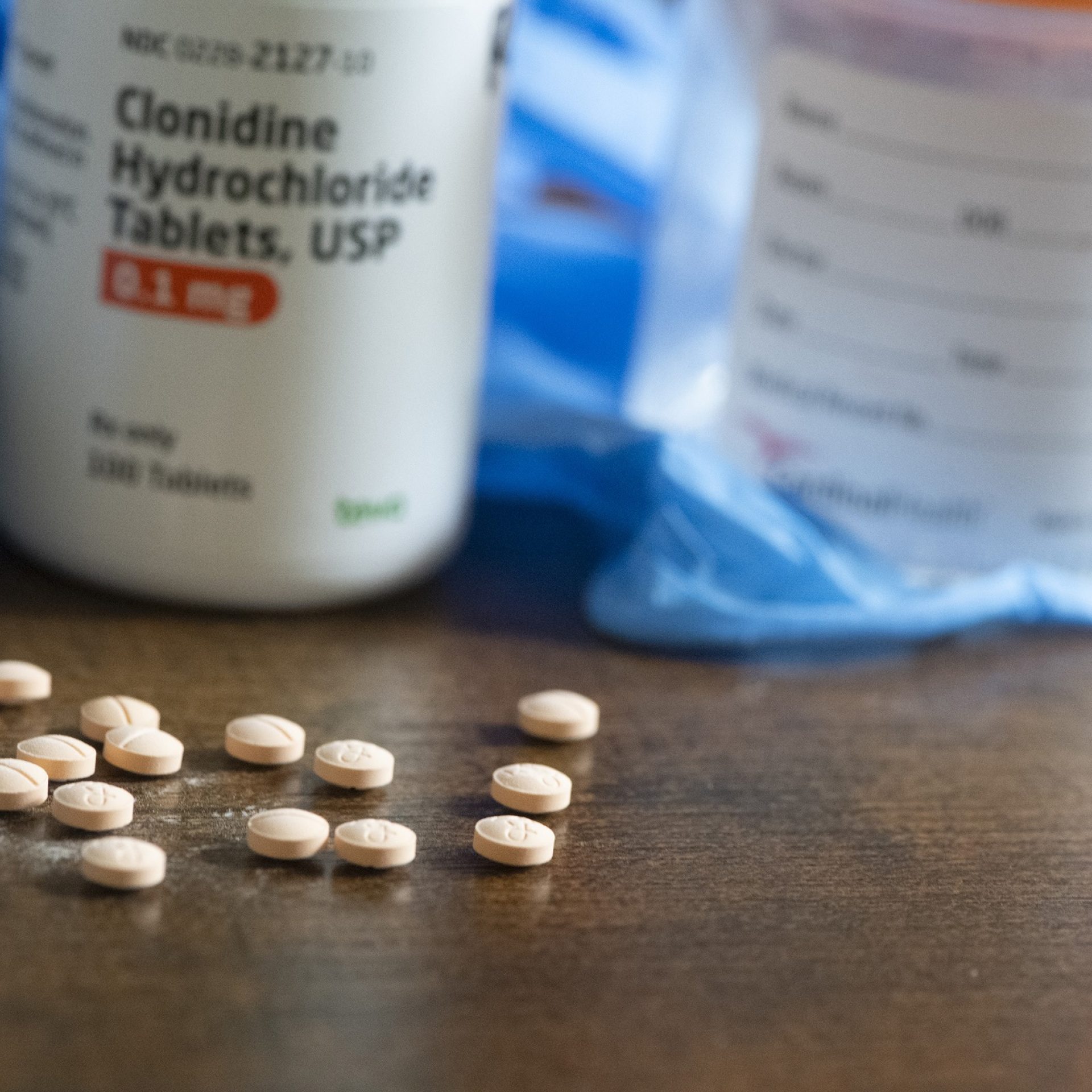 Prescription medication bottle and tablets used for blood pressure and kidney disease management.